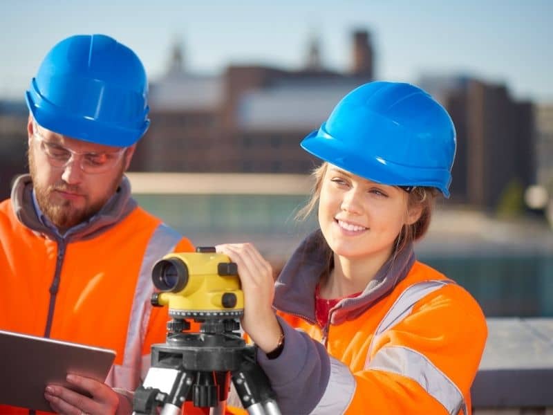 Survey professionals collecting measurements while evaluating commercial property for future development opportunities.