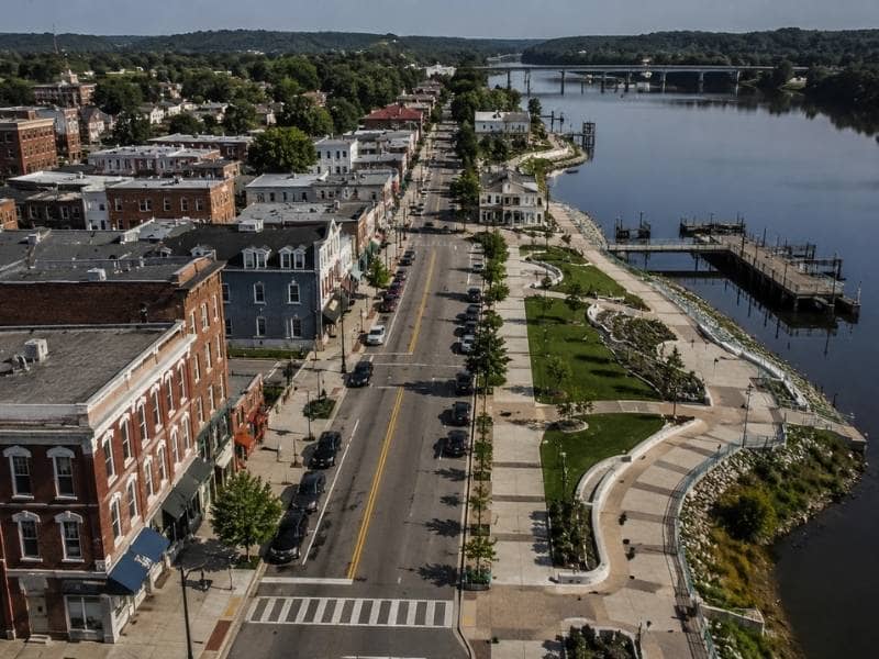 Historic downtown streets connecting to a landscaped public walkway along the riverfront