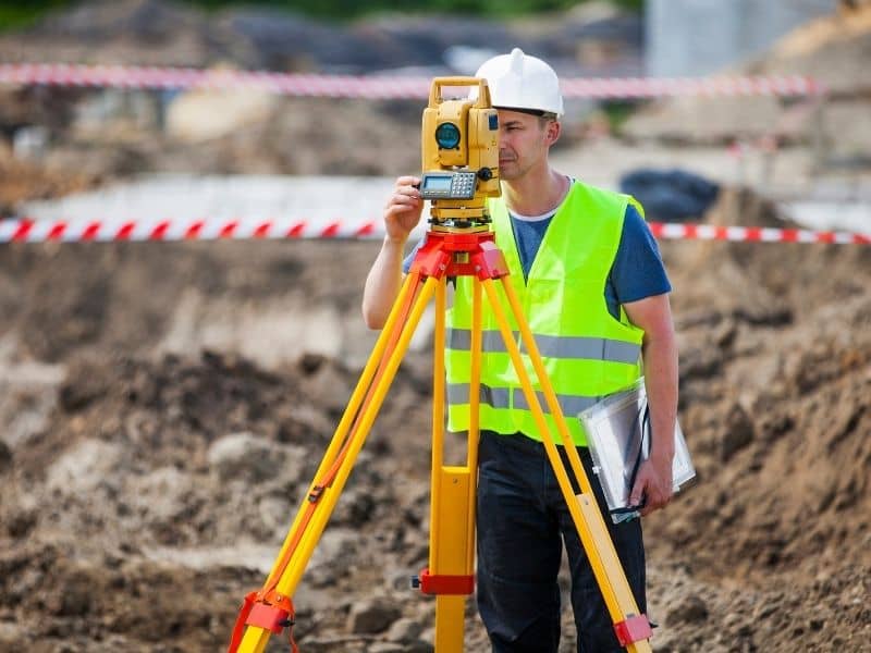 Surveyor using aerial LiDAR drone technology to map flood risk areas and analyze terrain elevation in a flooded residential landscape